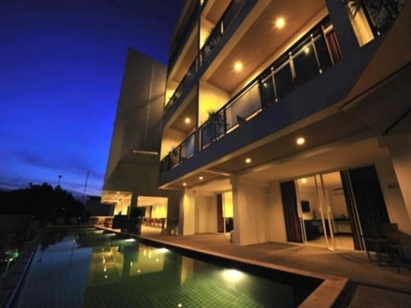 Boutique hotel exterior with swimming pool at night