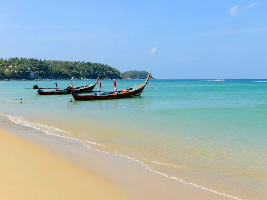 Nearby beach with traditional longtail boats