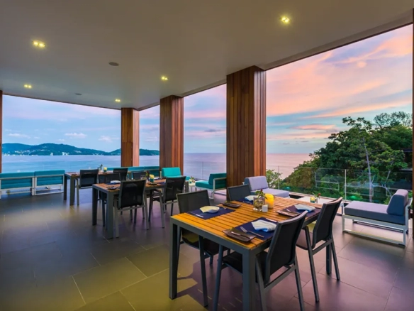 Outdoor dining area with sea view during sunset at luxury Phuket resort