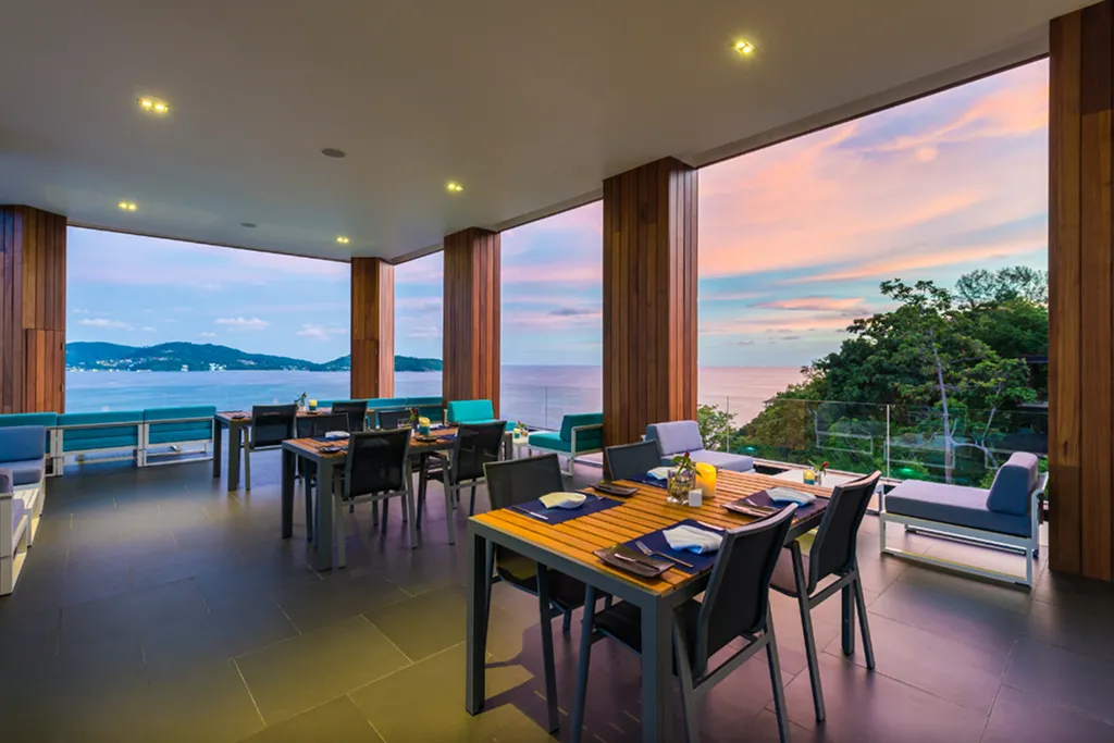 Outdoor dining area with sea view during sunset at luxury Phuket resort