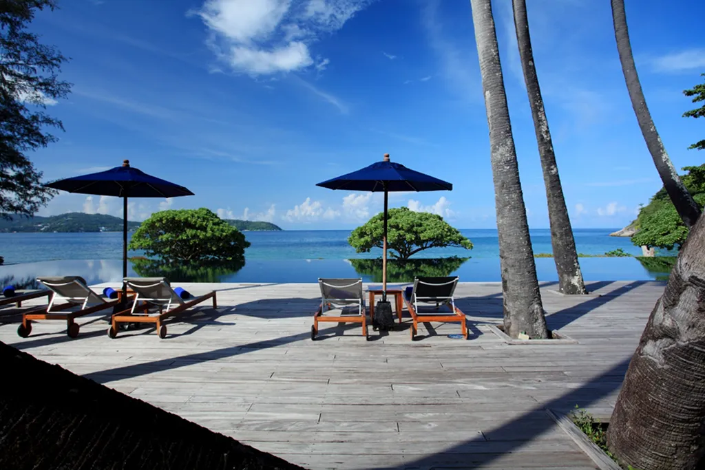 Poolside sunbeds with palm trees in Phuket