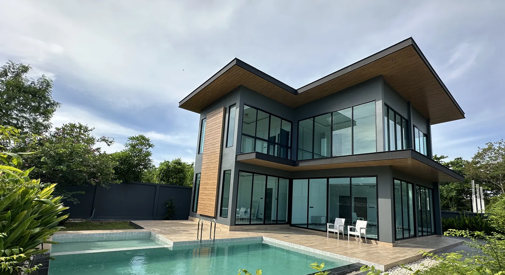 Exterior view with swimming pool and building layout of villa for sale in Bang Lamung Chonburi