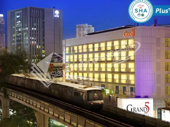 Grand 5 Hotel Plaza building exterior view next to Bangkok BTS skytrain line