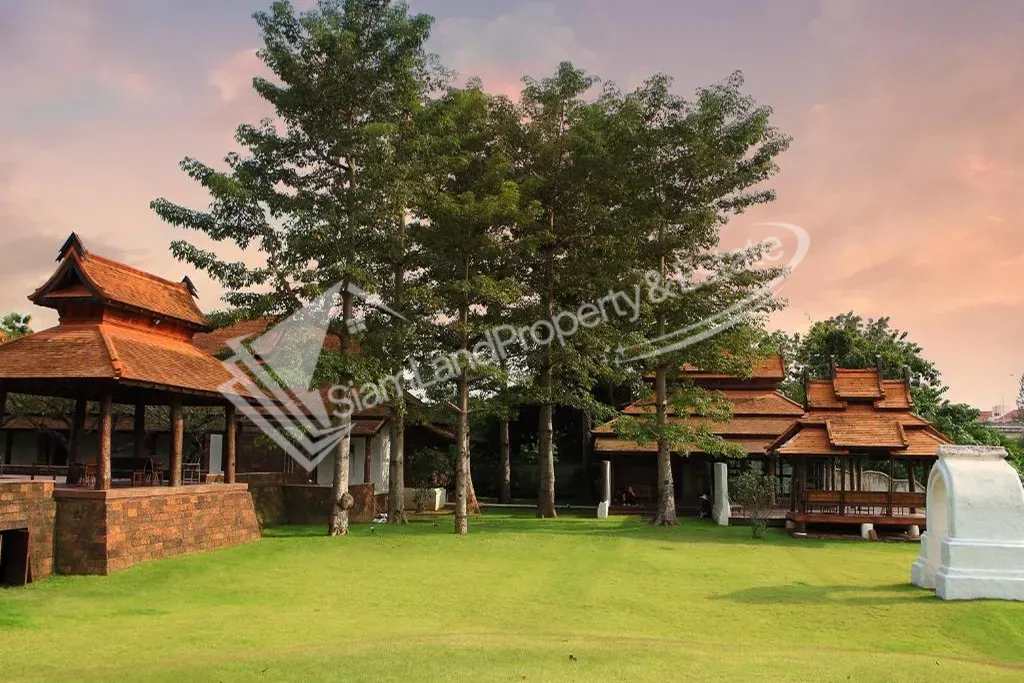 Beautiful resort garden featuring a well-maintained green lawn and traditional northern Thai villas